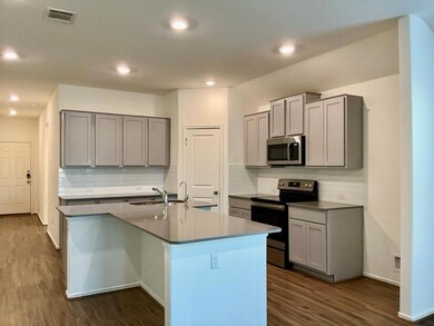 Kitchen with stainless steel appliances, gray cabinets, dark wood-style floors, tasteful backsplash, and recessed lighting