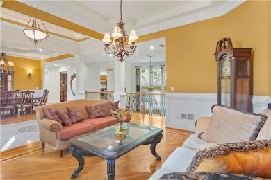 Living room featuring a raised ceiling, crown mold