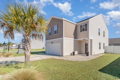 View of side of home featuring a yard and a garage