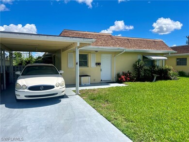 View of front of house with a front yard and a car