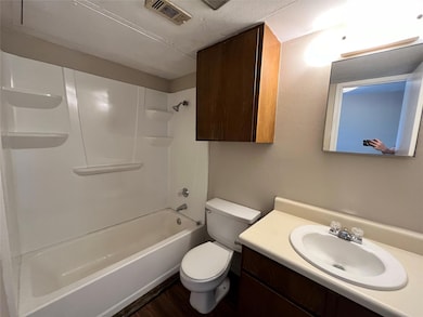 This bathroom has a shower/tub combination. Notice the extra cabinet space over the toilet.