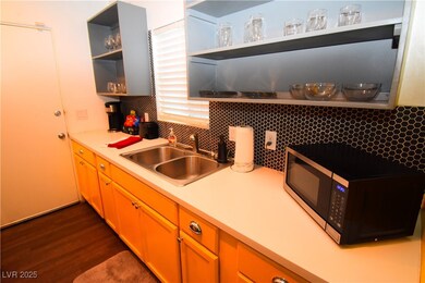 Kitchen with open shelves, black microwave, light