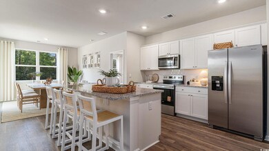 Kitchen featuring stainless steel appliances, a kitchen island, dark wood-style flooring, light stone counters, and recessed lighting