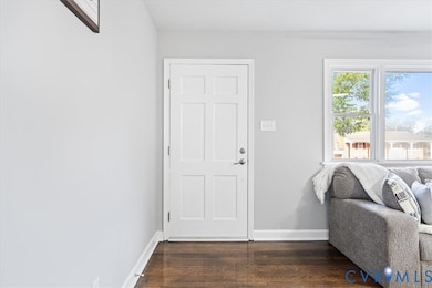Entryway with baseboards and dark wood-style flooring