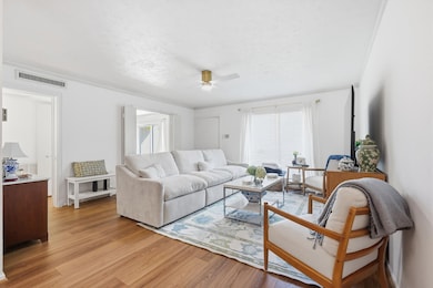 Spacious living area with new floors and great views overlooking the pool area.