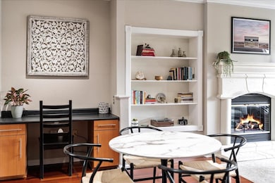Dining room with wood finished floors, a fireplace, and built in features