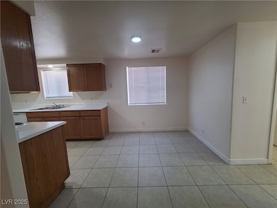 Kitchen featuring light countertops, light tile pa