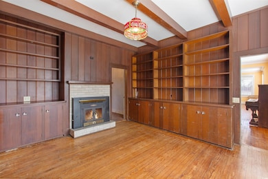 Unfurnished living room featuring beam ceiling, a 