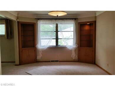 Spacious Formal Dining area with large window and 2 blonde wood built-in china cabinets with lights! Wonderful mid-century lighting.