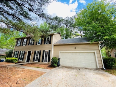 Colonial-style house featuring a garage and drivew