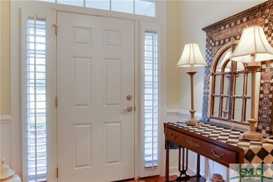 Foyer with plantation shutters, hardwood floors an