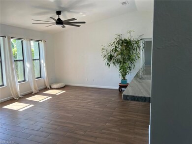 Unfurnished room with dark wood finished floors and ceiling fan