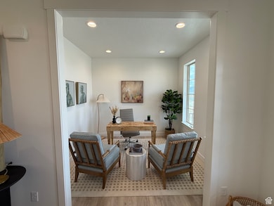 Office space with a textured ceiling, light wood finished floors, baseboards, and recessed lighting