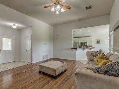 Living area featuring light wood-type flooring and a ceiling fan