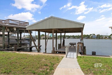 Dock area with a water view, boat lift, and a yard