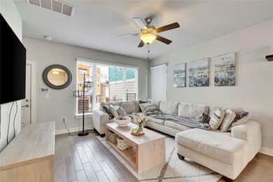 Living area with baseboards, ceiling fan, visible