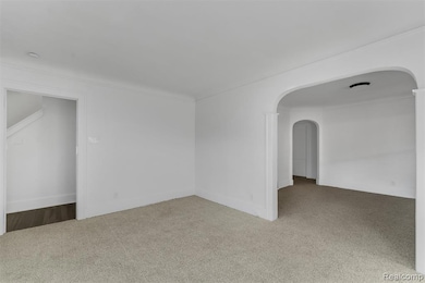 Spare room with carpet floors and arched walkways