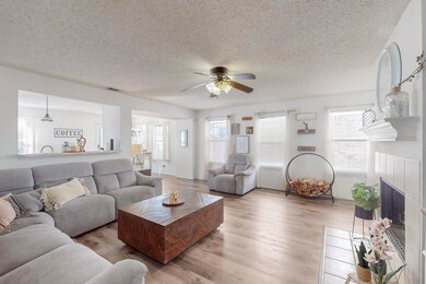 Living room featuring ceiling fan, a textured ceil