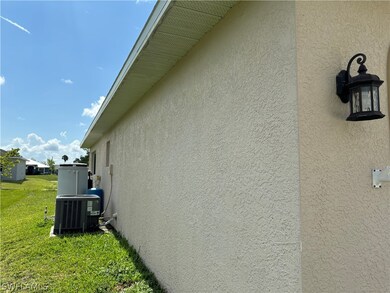 View of side of home with a yard and central AC unit