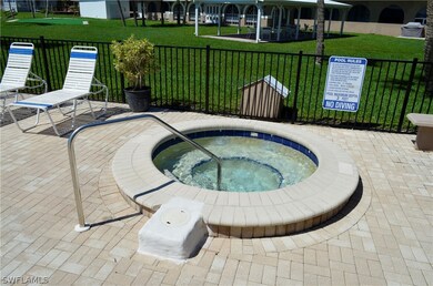 View of pool featuring a hot tub, a patio area, and a lawn
