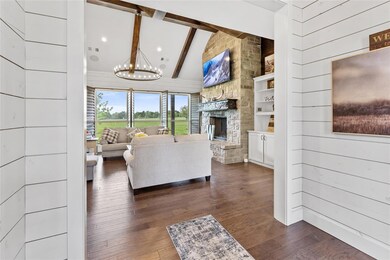 Living area featuring a stone fireplace, a chandel