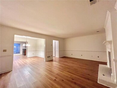 Kitchen with appliances with stainless steel finishes, crown molding, dark brown cabinets, and light wood-type flooring