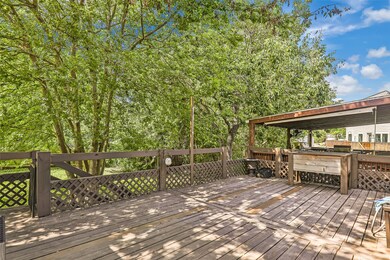Spacious wooden deck with a covered area and lush