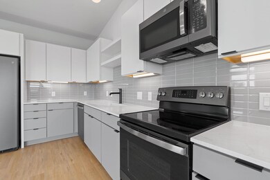 Kitchen featuring open shelves, a sink, light woo