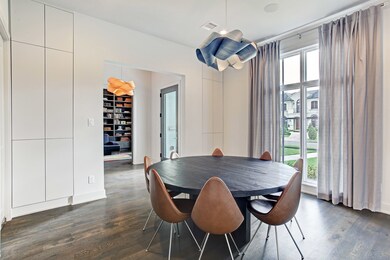 Formal dining room has floor to ceiling windows, hidden storage, beautiful chandelier, and wood flooring.