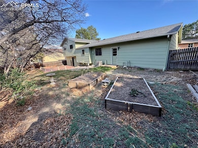 Back of house featuring fence, a vegetable garden,