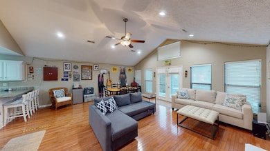 Living room featuring lofted ceiling, ceiling fan,