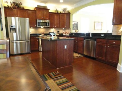 Gorgeous kitchen with attractive hardwood floors, durable granite counter tops, under cabinet lighting, crown molding and deep stainless sink, 