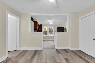 Unfurnished living room with light wood-type flooring and ceiling fan