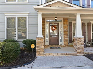 Doorway to property featuring covered porch and stone siding
