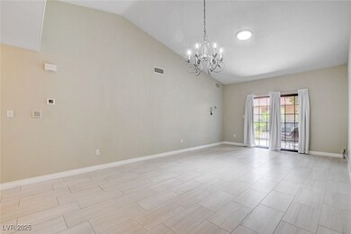 Unfurnished room with a chandelier and high vaulte