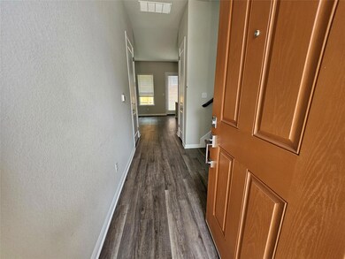 Hall featuring baseboards, a textured wall, dark 