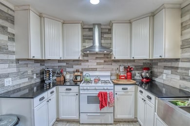 Kitchen featuring tasteful backsplash, white cabin