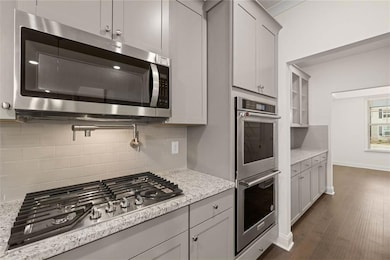 Kitchen featuring light stone countertops, gray ca
