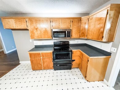 Kitchen with electric range and a textured ceiling