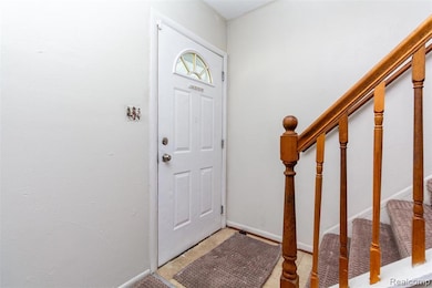 Entryway with stairway and baseboards