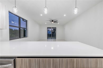Kitchen with light brown cabinetry, recessed lighting, modern cabinets, ceiling fan, and open floor plan