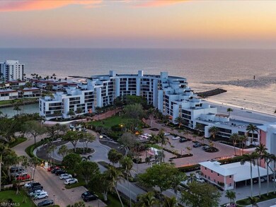 Aerial view at dusk of a view of apartment building / complex and view of water and beach