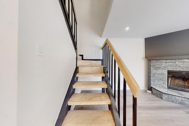 Stairway featuring recessed lighting, a fireplace,
