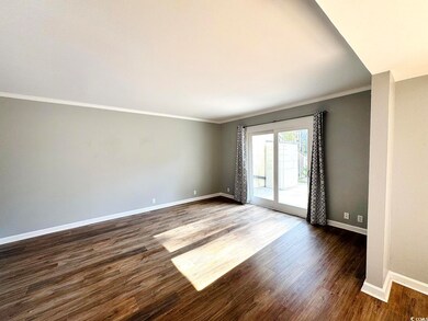 Spare room with crown molding and dark wood-type f