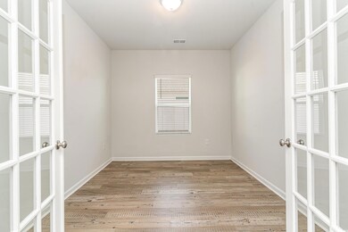 Spare room featuring visible vents, french doors, baseboards, and wood finished floors