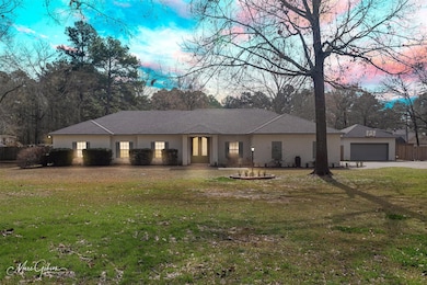 View of front of home featuring a garage and a yar