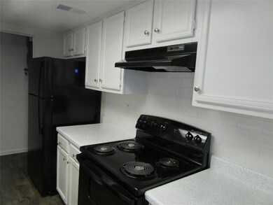 Kitchen with white cabinets, dark wood-type floori