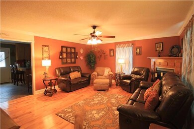 Living Room - With ceiling fan, crown molding and hardwood flooring.