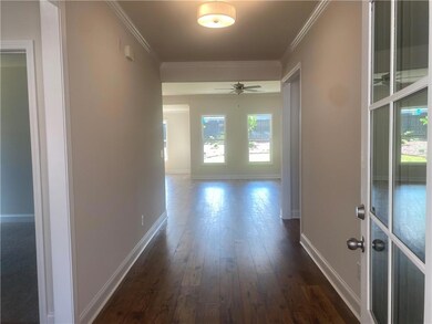 Hall with crown molding and wood-style flooring