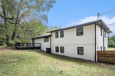 Rear view of property with a yard, a wooden deck, 